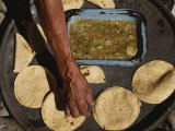 A Vendor Displays a Sample of Local Mexican Cooking with Tortillas