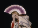 An Geisha Holds a Fan in Front of Her Face During a Formal Ceremony