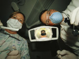 A Dentist and Dental Hygienist Prepare for an Examination