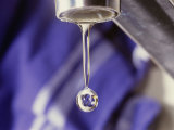 A Close-up of a Faucet with a Single Drop of Water Coming out of It