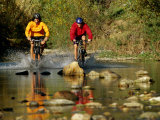 Mountain Bikers Enter a Rocky Stream
