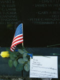 Rose, Flag, and Note of Remembrance Left by a Family at Memorial Wall