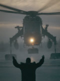 A Man Guides a Landing Helicopter