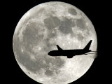 Buy A Jet Plane Passes in Front of the Full Moon Above Surfside, Fla. at AllPosters.com