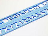 Blue Ruler Against White Background with Tracing of Alphabet and Numbers