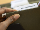 Woman Holding Health Insurance Folder