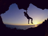 Silhouette of a Man Hanging from a Rock