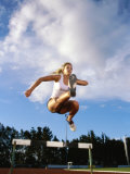 Low Angle View of a Female Athlete Jumping Over a Hurdle