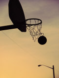 Silhouette of a Basketball Going Through a Basketball Net