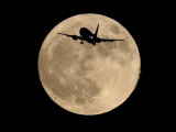 Buy An Airliner is Silhouetted against a Full Moon at AllPosters.com