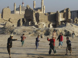 Buy Afghan Boys Play Soccer Near a Mosque and Ruined Buildings During the Early Morning at AllPosters.com