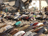 Buy Kashmiri Eartquake Survivors Pray Amid the Debris of a Destroyed Building During the Eid Al-Fitr at AllPosters.com