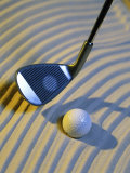 Close-up of a Golf Ball on the Sand and a Golf Club