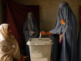 An Afghan Woman Wearing a Burqa Casts Her Ballot at a Polling Station