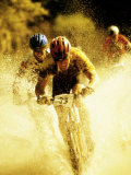 Young Men Riding Bicycles Through Water