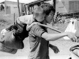 A South Vietnamese Father Carries His Son and a Bag of Household Possessions