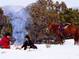 Buy Cowboy with Cowgirl Sitting Near Camp Fire in Snow, Their Horse Standing Nearby, U.S.A. at AllPosters.com