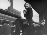 Actress Patricia Neal Sitting on Her Luggage on the Platform of a Train Station During a Stopover