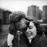 Woman Profiling a Big Smile While Adoring Her Poodle Wearing Large Swiss Watch on Dog Collar