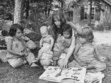 Actress Mia Farrow Reading to Her Adoptive Vietnamese Daughter Lark and Others Outside at Home