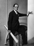 Architect Sir Hugh Casson Standing on Staircase with Blueprint in One Hand and Ruler the Other