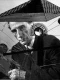 Marcel Duchamp Sitting Behind Example of Dada Art