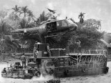 US Army Helicopter Making Mid Stream Landing Atop an Armored Troop Carrier