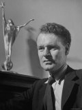 Buy Director Anthony Asquith Standing Next to Mantle Holding Academy Award for "Johnny in the Clouds" at AllPosters.com