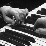 The Hands of Pianist Josef Hofmann on Piano Keyboard