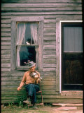 Country Musician, Fred Price, Sitting Outdoors in Front of Old House Playing the Fiddle