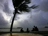Buy Visitors Sit by the Sea in Bombay, India, July 16, 2006 at AllPosters.com