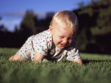A Baby Boy Crawls Through the Green Grass