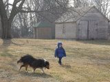 A Young Male and His Sheltie Dog Walk Through a Historic Farm