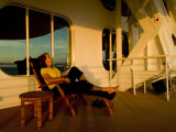 Woman Sitting on a Deck Chair of a Cruise Ship Watching the Sunset