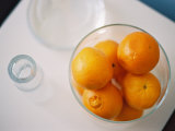 Oranges in Bowl Next to Drinking Glass
