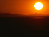 Buy The Rising Sun Hovers over Distant Mountains at AllPosters.com
