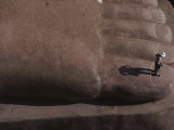 A Person Stands on the Big Toe of the Sitting Buddha Statue at Leshan