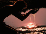 Buy A Person Dips His Hands in the Headwaters of the Mississippi River at AllPosters.com