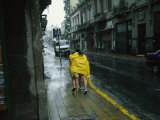 Buy Two People Share a Raincoat as They Hurry Down a Rainy Street at AllPosters.com