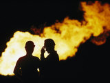 Natural Gas Workers Silhouetted by Burning Dross
