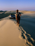 Woman Walking Towards Car on Sand Dune Ridge, Khor Al-Adaid, Qatar