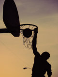 Silhouette of a Man Slam Dunking a Basketball
