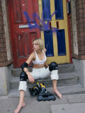Woman on Doorstep Putting on Rollerblades
