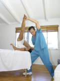 Man Helping a Young Woman Stretch