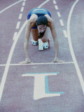 High Angle View of a Young Woman at the Starting Position of a Running Track