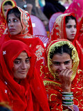 Two Pakistani Brides, Smile During a Mass Wedding Ceremon