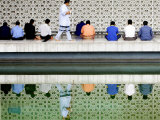 Buy With the Water Reflection, a Muslim Man Walks Past Others Offering the Friday Prayer at a Mosque at AllPosters.com