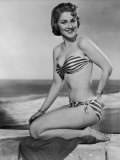 Buy Smiling Young Woman Perches on a Stone Wall in a Striped Bikini at AllPosters.com