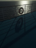 Life Preserver Hanging on a Railing of a Cruise Ship Deck at Sunset