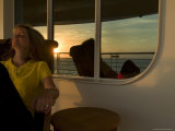 Woman Sitting on the Deck of Cruise Ship with Reflection of Sunset